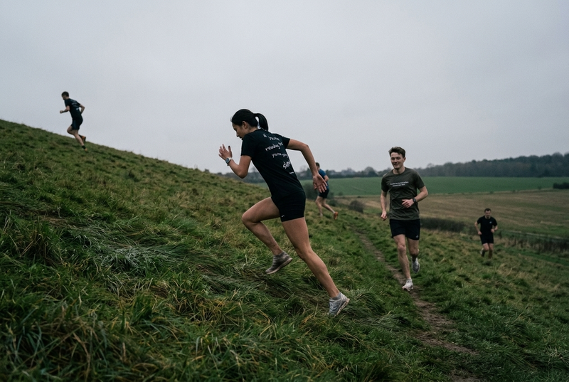 Runners doing hill repetitions, one running up while another jogs back down